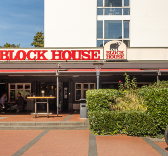 BLOCK HOUSE Frankfurt Westend – Steakhouse mit Terrasse Außenansicht des BLOCK HOUSE Frankfurt Westend mit Terrasse, Eingang zum Steakhouse und Gästen im Außenbereich
