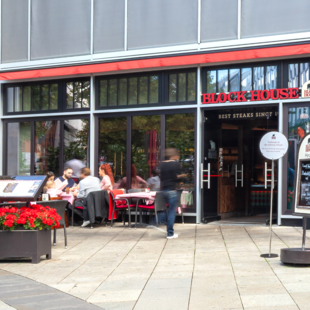 BLOCK HOUSE Stuttgart Königstraße Außenansicht des BLOCK HOUSE Stuttgart Königstraße mit Terrasse und Gästen vor dem Restaurant.