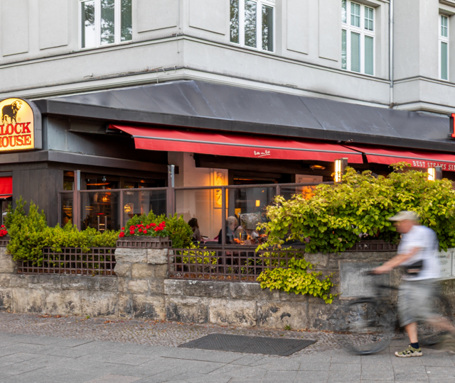 BLOCK HOUSE Berlin Theodor-Heuss-Platz – Steakhouse mit Terrasse Terrasse des BLOCK HOUSE Berlin Theodor-Heuss-Platz mit Tischen und Gästen vor dem Steakhouse