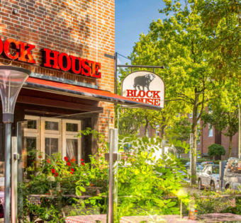 BLOCK HOUSE Hamburg Eidelstedt – Steakhouse mit Terrasse Terrasse vor dem BLOCK HOUSE Hamburg Eidelstedt mit Tischen und rot-weiß karierten Tischdecken vor dem Steakhouse